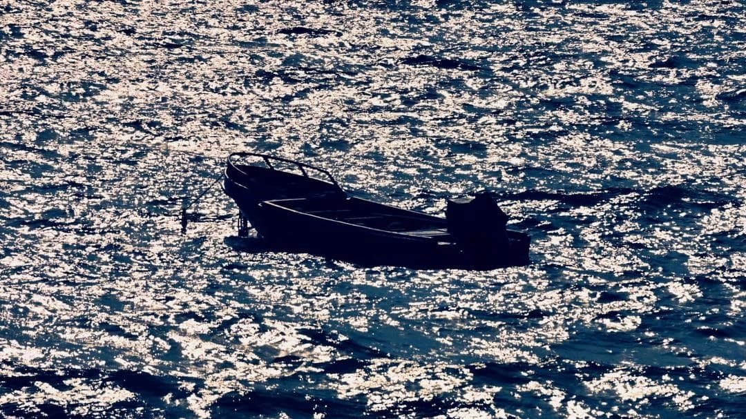 A small boat alone on a glittering sea off Crucita, Ecuador
