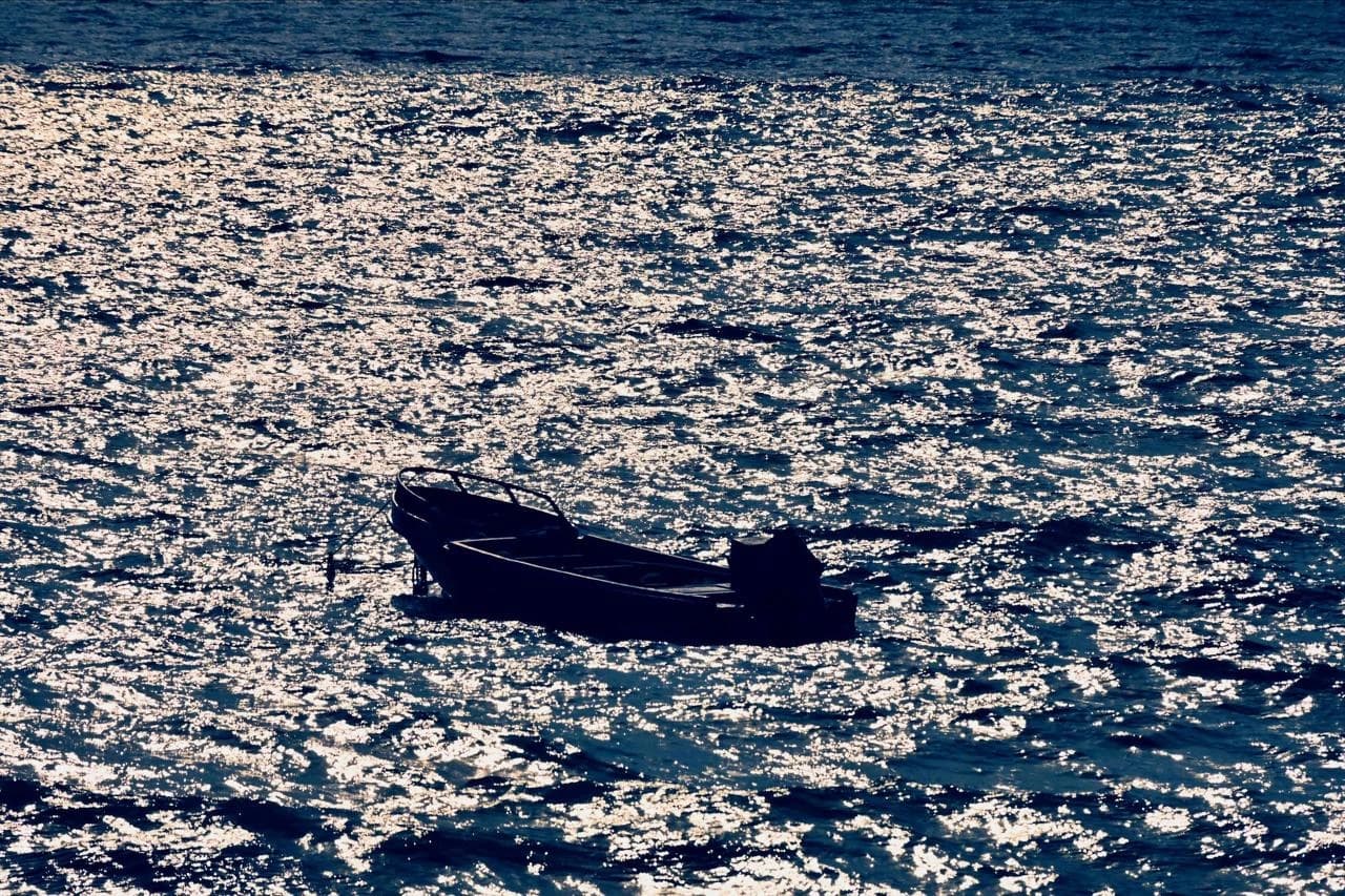 A small boat alone on a glittering sea off Crucita, Ecuador